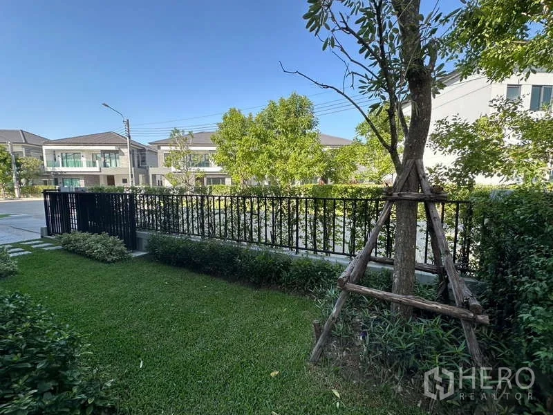 บ้าน ให้เช่าในBang Phli, Samut Prakan - สวนหน้าบ้านจัดแต่งสนามหญ้า ต้นไม้ และรั้วเหล็กภายในโครงการ