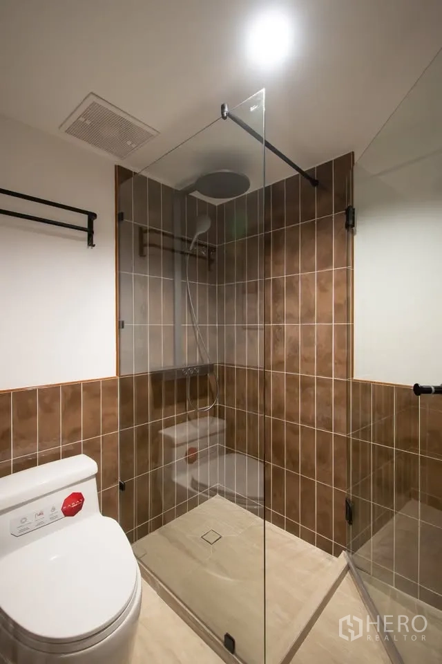 公寓 for rent in Watthana, Bangkok - 现代卫浴，玻璃干湿分离淋浴间、棕色瓷砖与坐便器。