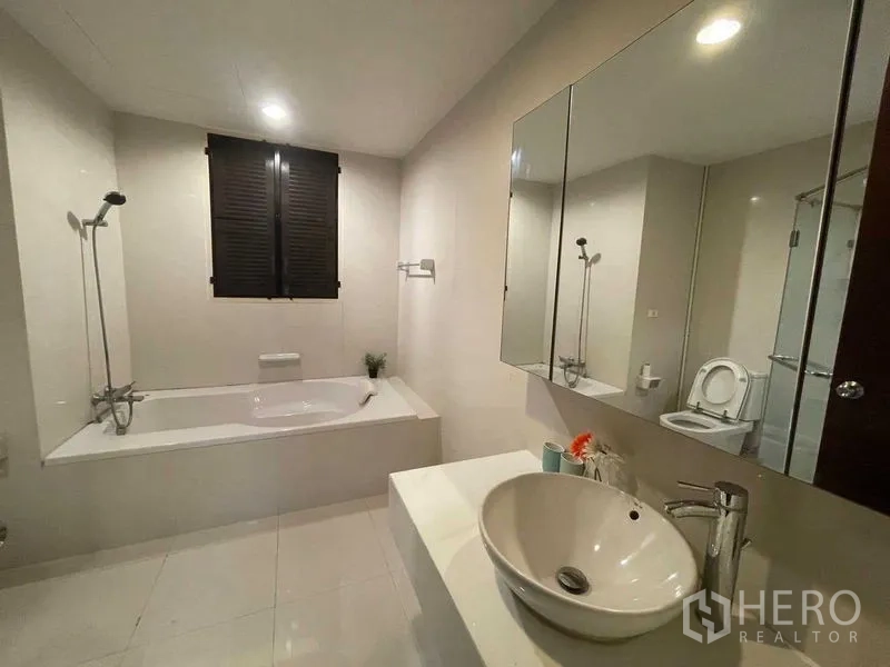 Condominium for rent in Din Daeng, Bangkok - Bright bathroom with full-size bathtub, vessel sink and mirrored cabinet.