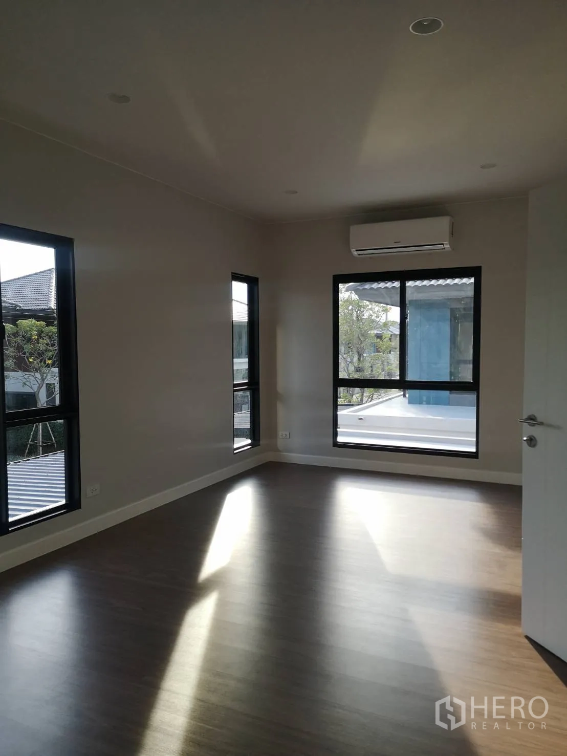 บ้าน ขายในLam Luk Ka, Pathum Thani - ห้องนอนรับแสงธรรมชาติ มุมกระจกสองด้าน พื้นลายไม้ และเครื่องปรับอากาศ