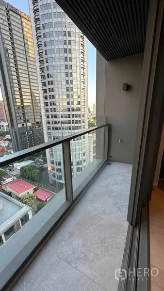 Condominium for sale - Private balcony with glass railing overlooking high‑rise buildings in Thonglor.