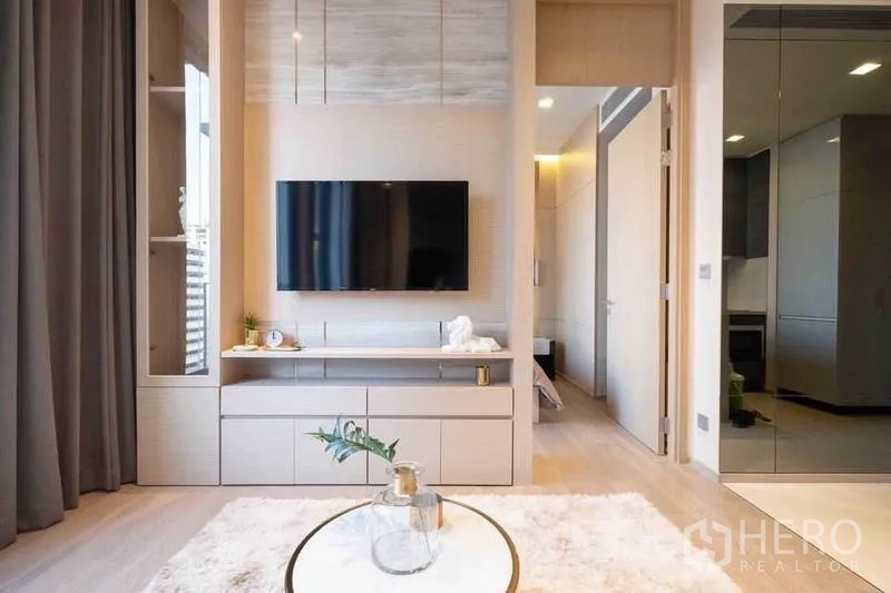 Condominium for rent in Watthana, Bangkok - Front view of TV cabinet and coffee table set on a soft rug in the living room.