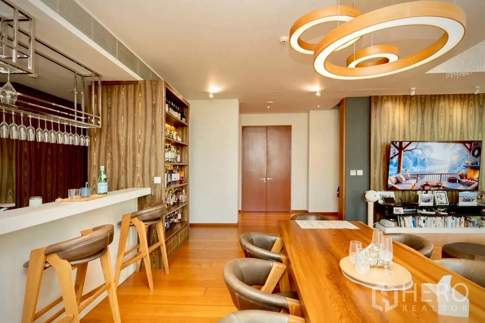 Condominium for sale in Sathon, Bangkok - Entertainer’s bar with counter, bottle shelves, bar stools, and dining table.