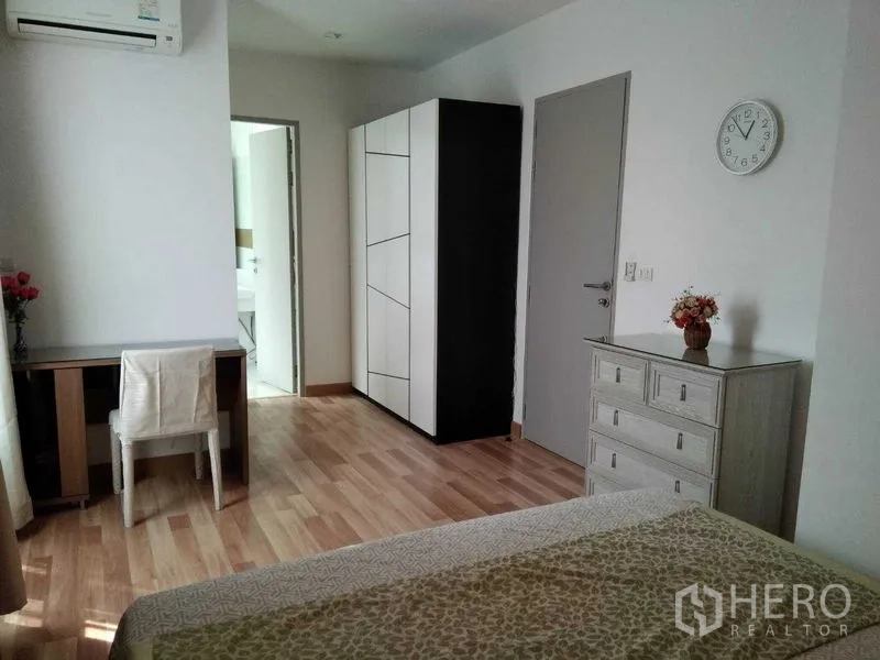 Condominium for rent in Watthana, Bangkok - Master bedroom with desk, wardrobe, and door to en-suite bathroom.