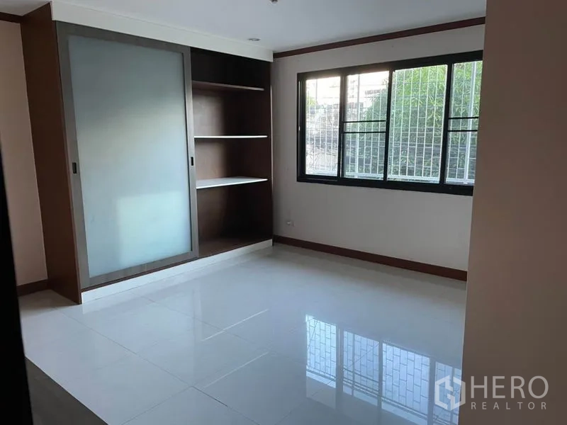 Office Space for rent in Khlong Toei, Bangkok - Corner office room with windows on two sides and built-in shelving for storage