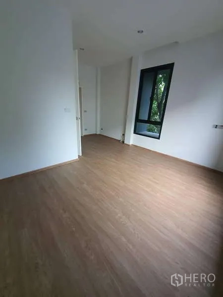 独立式住宅 出租在Phra Khanong, Bangkok - 宽敞卧室，木地板与高挑转角窗。