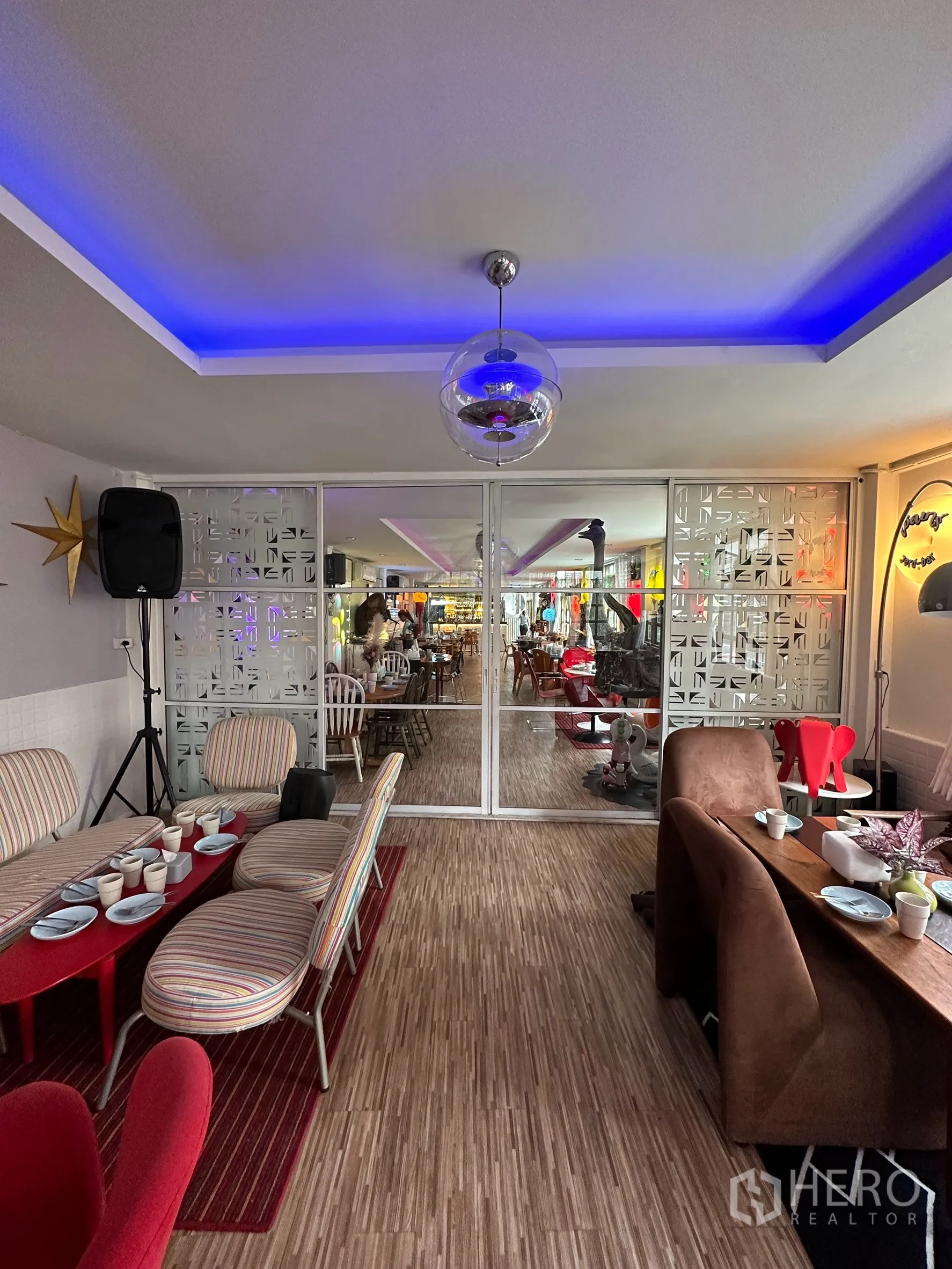 Retail Space for rent in Sathon, Bangkok - Lounge-style seating with striped chairs, blue LED ceiling lighting, and a glass partition to the main area.