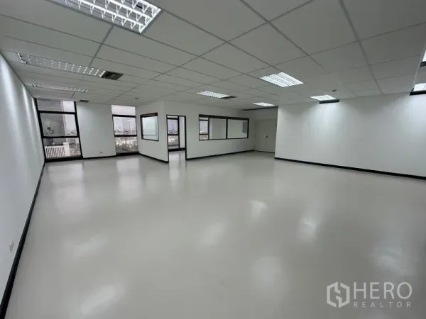 办公空间 出租 - 明亮的开放办公区，窗外城市景观与吊顶照明清晰可见。