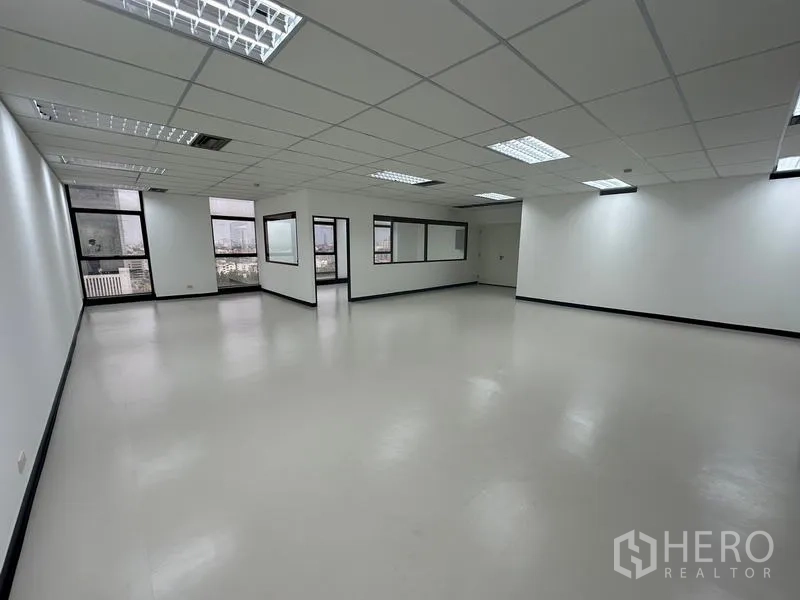 办公空间 出租 - 明亮的开放办公区，窗外城市景观与吊顶照明清晰可见。