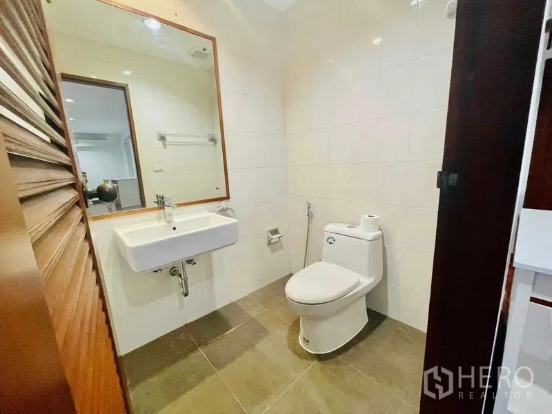 公寓 出租 - 明亮客卫，设镜柜、台盆和坐便器。