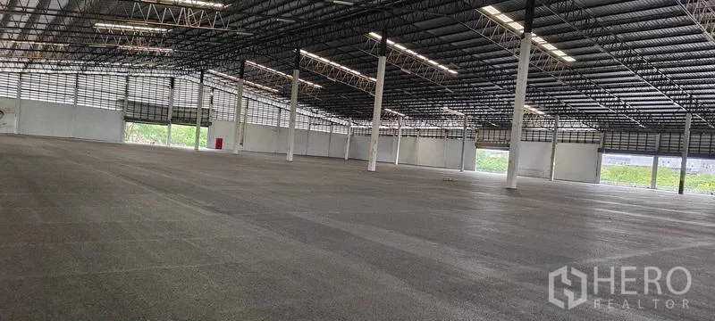 Warehouse for rent in Bang Pakong, Chachoengsao - Clear-span storage hall with wide column grid, natural ventilation louvers and multiple large access openings.