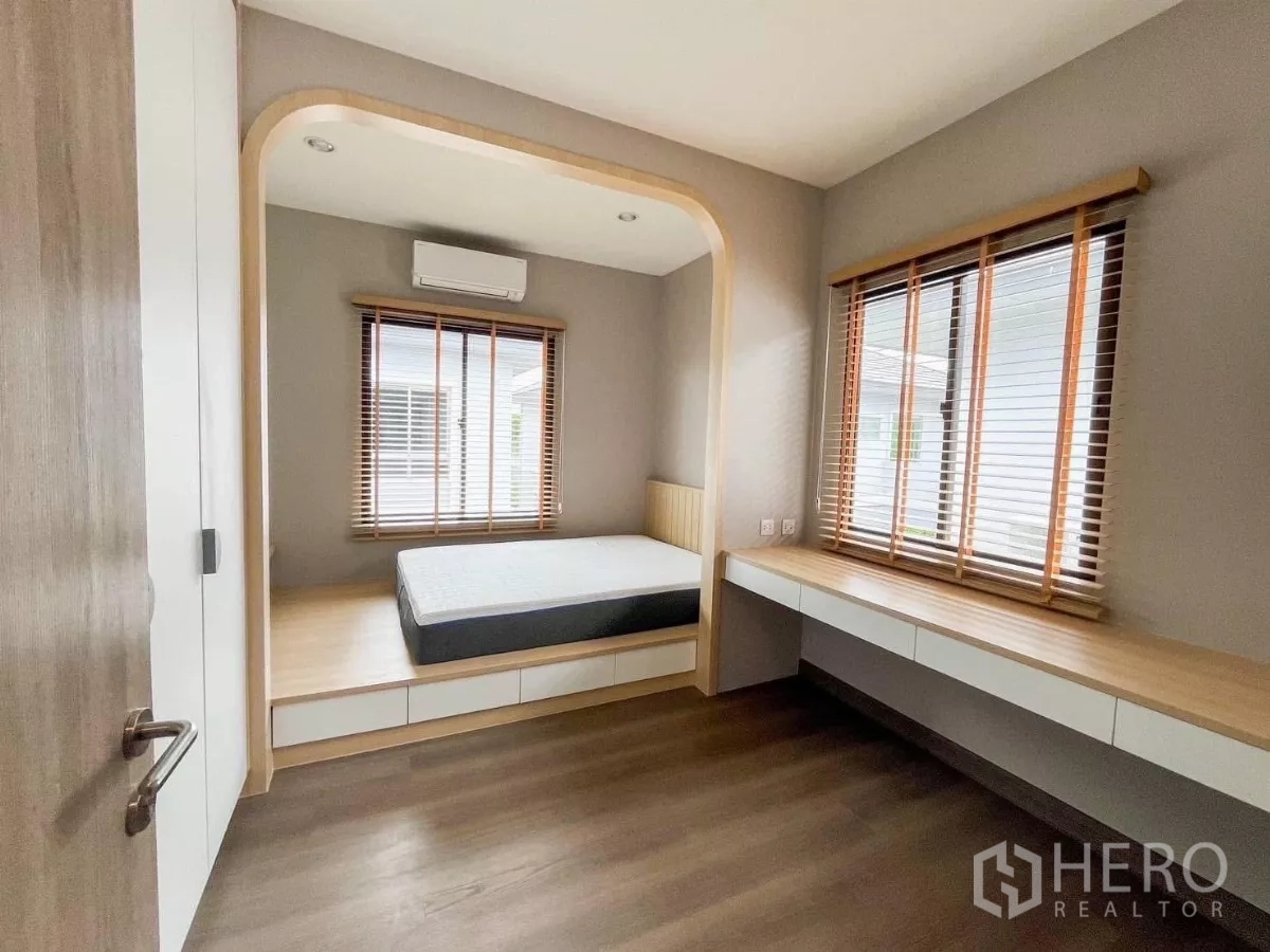 บ้าน ให้เช่าหรือขายในPrawet, Bangkok - ห้องนอนอบอุ่น เตียงยกระดับแบบมุมเว้า หน้าต่างมู่ลี่ไม้ และโต๊ะทำงานยาวบิลท์อิน