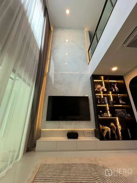 Detached House for rent in Bang Phli, Samut Prakan - Double-height living room with TV wall and illuminated display shelves.