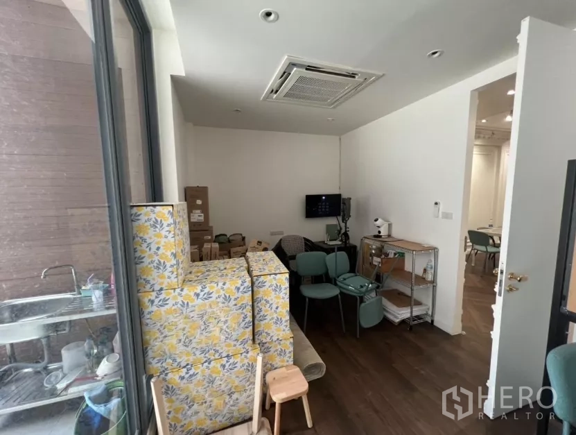 Retail Space for rent in Watthana, Bangkok - Compact back office with ceiling cassette air-conditioning and shelving near a service sink.