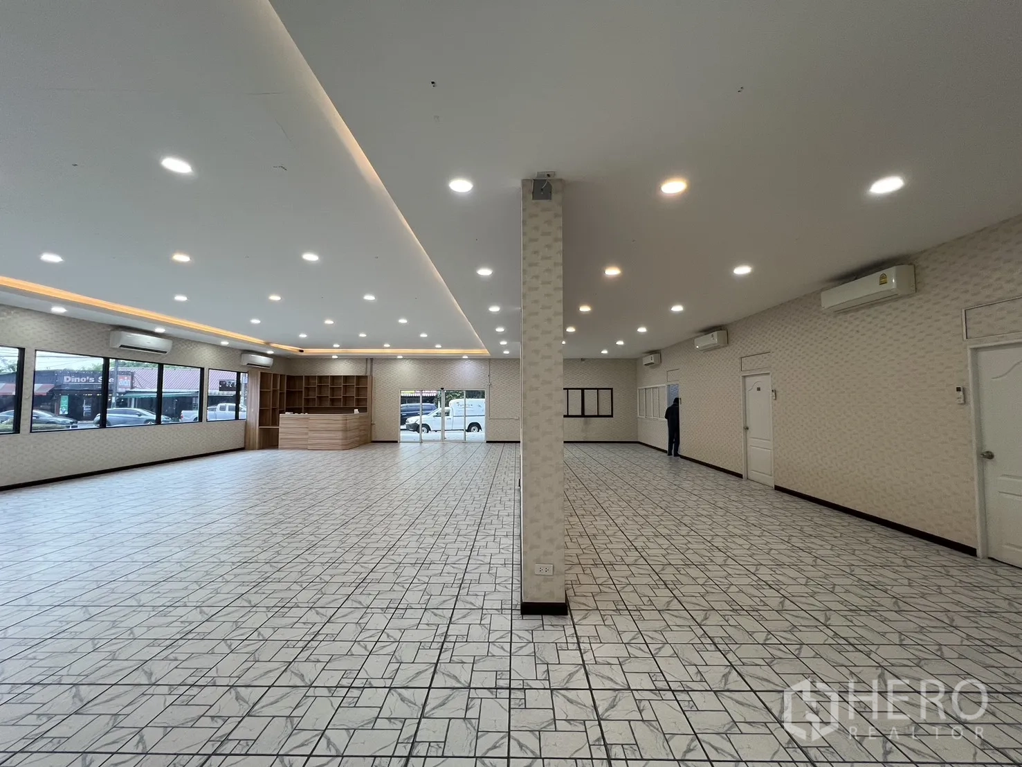 零售空间 for rent in Bueng Kum, Bangkok - 开放大厅，可见立柱、木质接待台、内置货架与窗面展示。