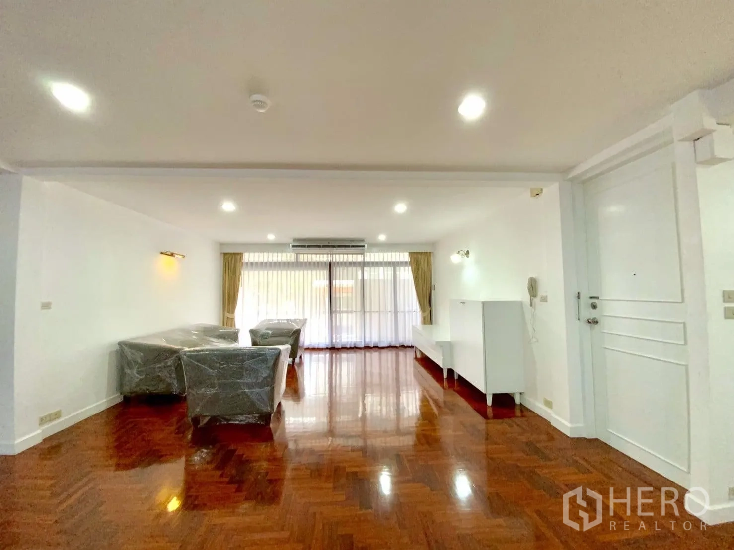 คอนโด ให้เช่าในWatthana, Bangkok - ห้องนั่งเล่นหันสู่ประตูระเบียงบานกว้าง แสงสว่างทั่วถึง มีโซฟาคลุมพลาสติก