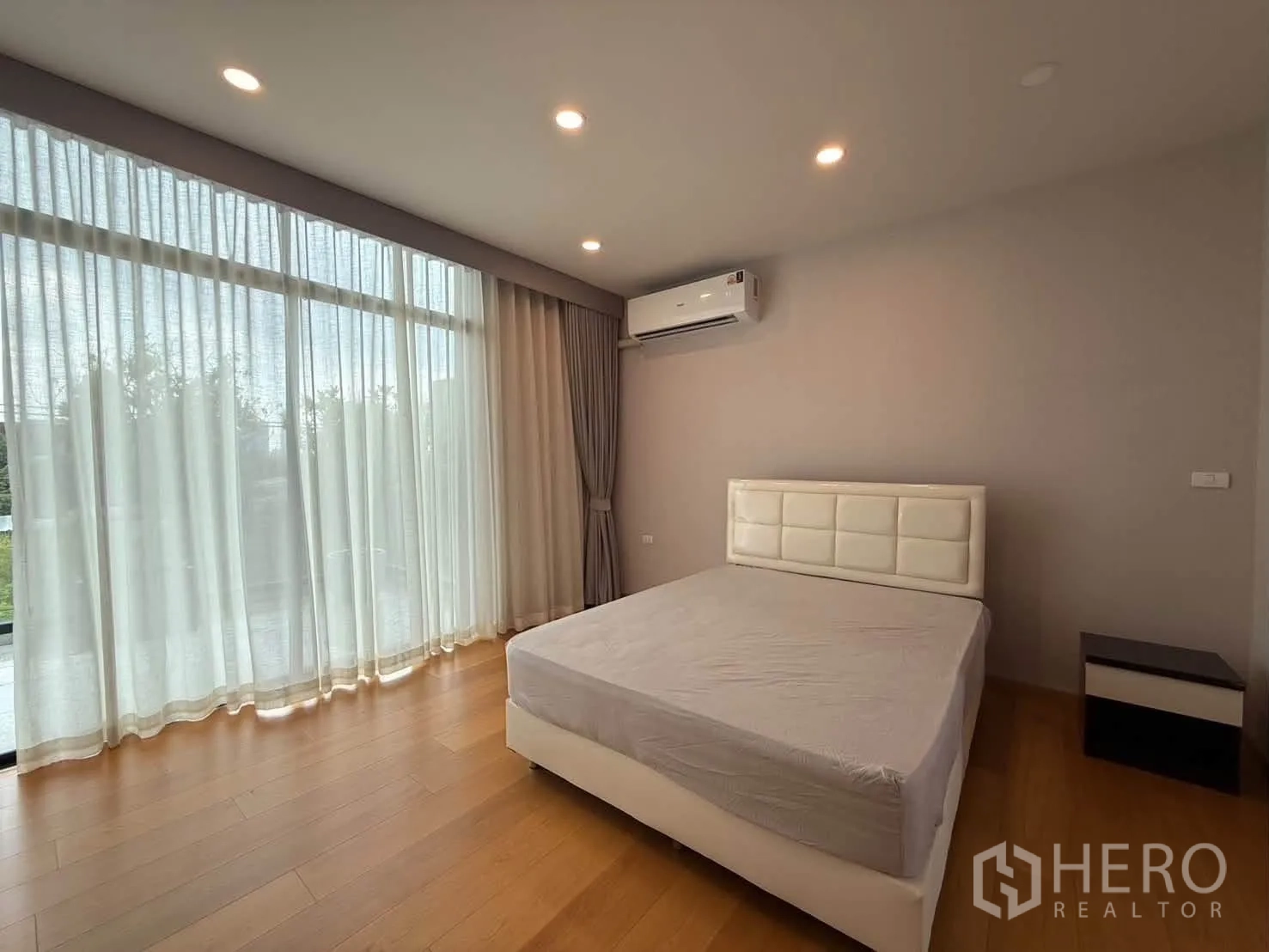 独栋房屋 for rent in Suan Luang, Bangkok - 卧室设落地窗、纱帘与壁挂空调。