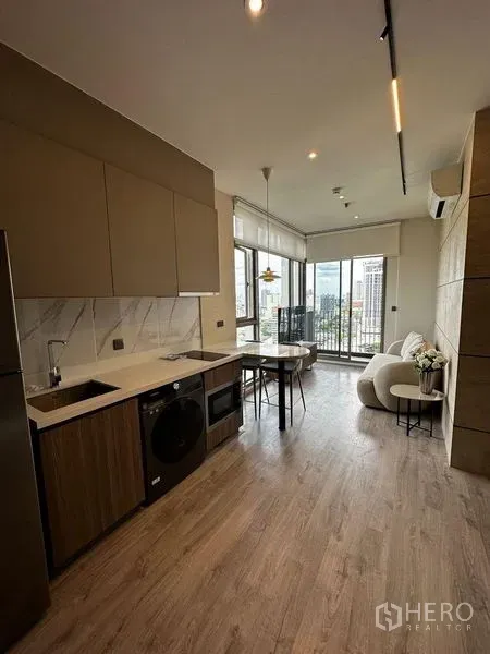 公寓 出租在Watthana, Bangkok - 现代厨房，大理石防溅板、内置洗衣机与面向阳台的餐吧台。