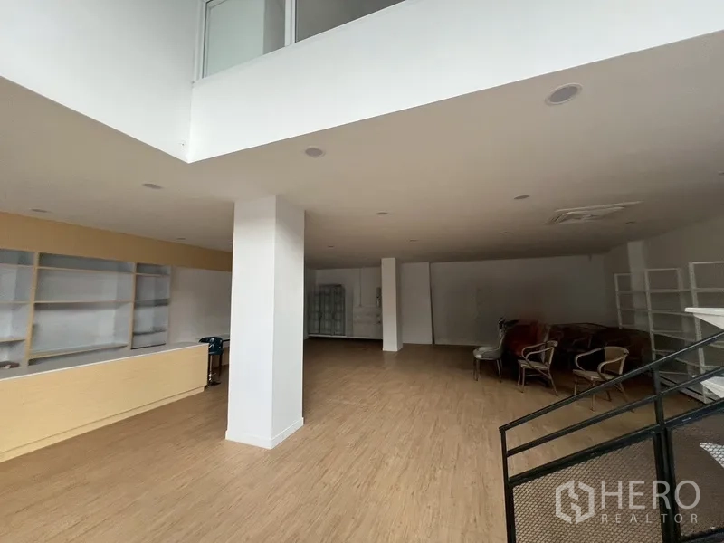 零售空间 出租在Watthana, Bangkok - 大面积无柱销售区，配货架与座椅，高挑空间