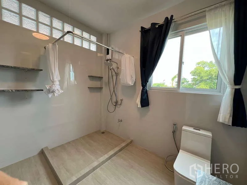 Detached House for rent in Chatuchak, Bangkok - Bright shower room with raised platform, window and toilet.