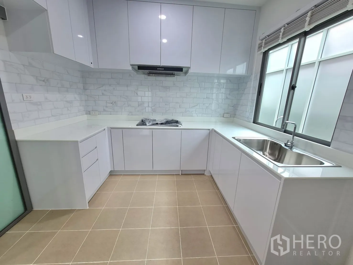 Detached House for rent in Lat Krabang, Bangkok - White L-shaped closed kitchen with stone counters and subway tiles.
