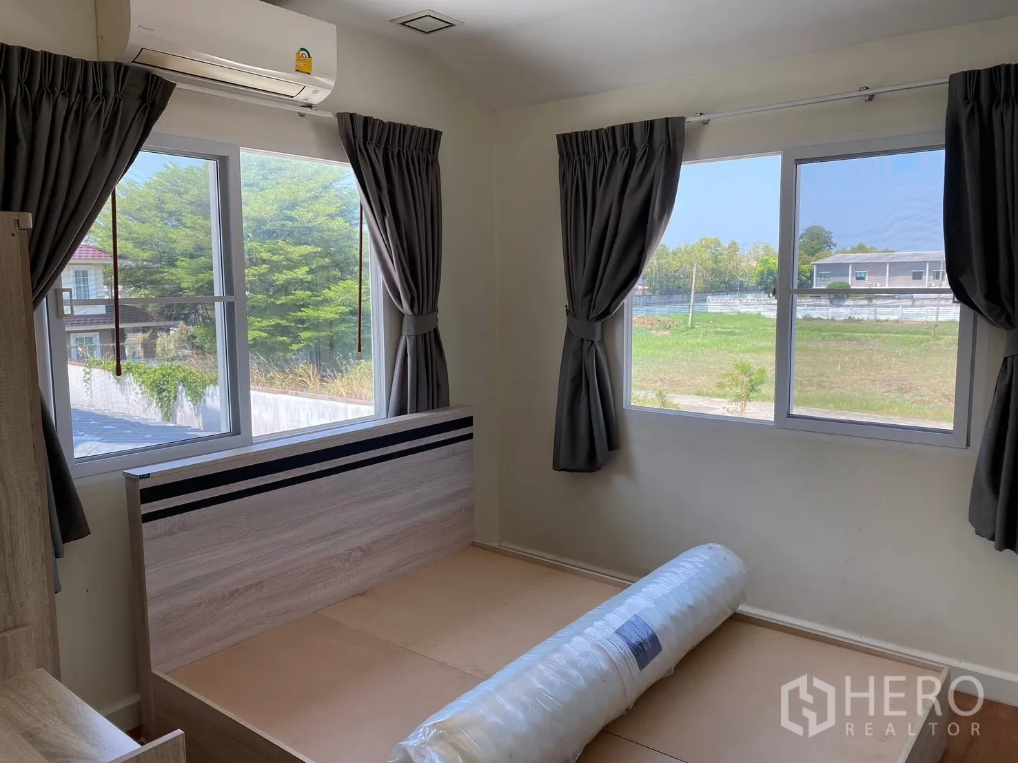 Detached House for rent in Prawet, Bangkok - Bedroom with multiple windows, bed base, and green view outside.
