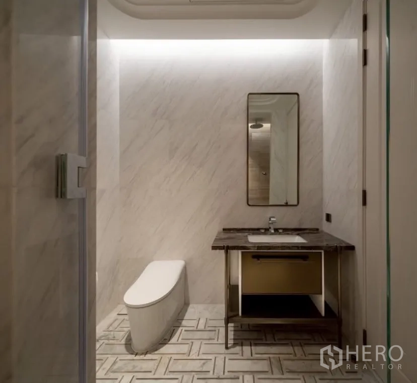 公寓 出租或出售在Pathum Wan, Bangkok - 现代卫浴，悬空洗手台、简洁坐便器与大理石墙地。