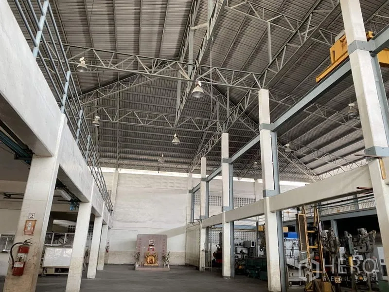 Factory for sale in Khlong Luang, Pathum Thani - Industrial hall with steel roof trusses, pendant lighting and open floor area.