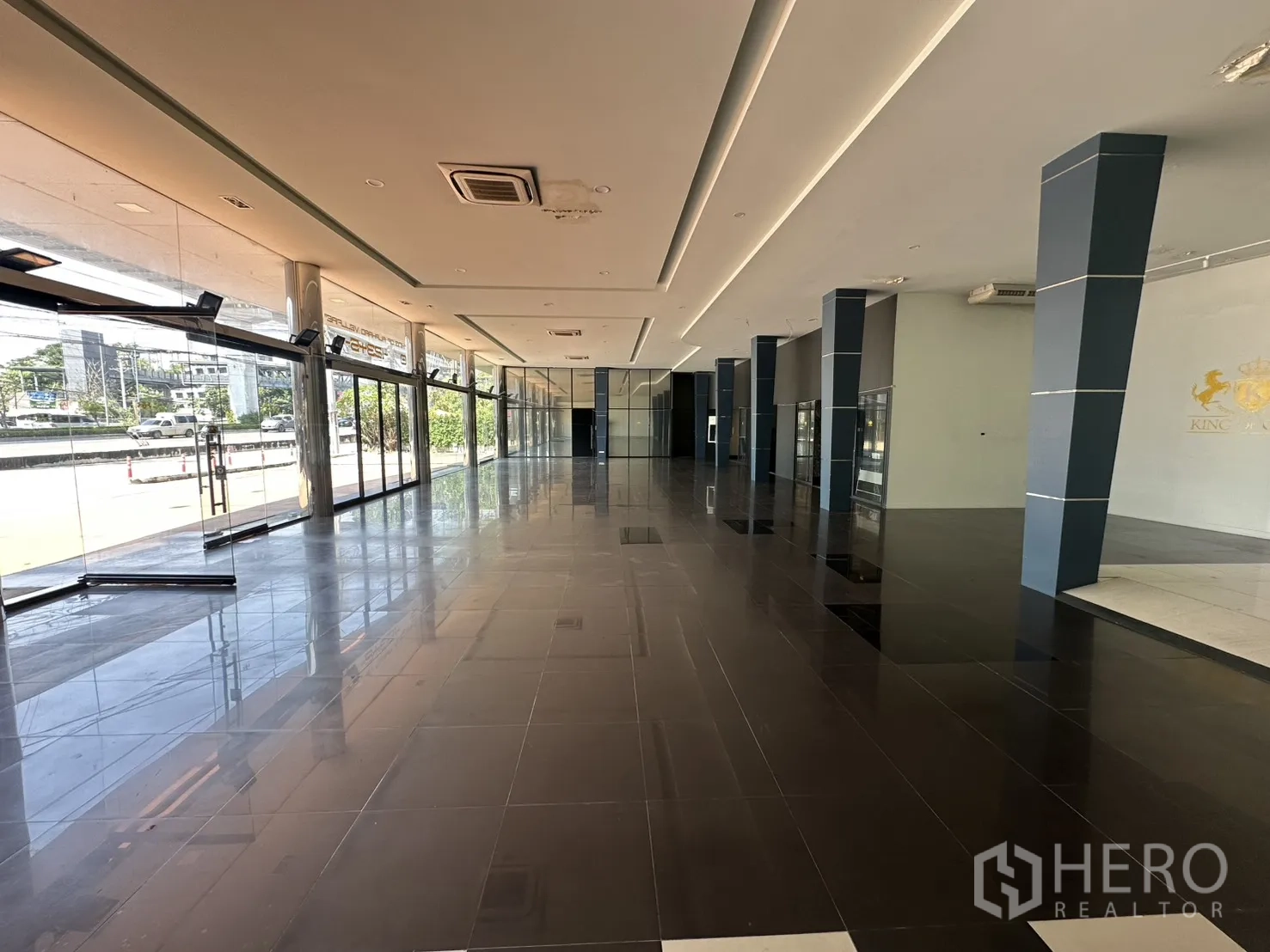 展厅 for rent in Suan Luang, Bangkok - 明亮的展厅通道，蓝色立柱与嵌入式灯带。