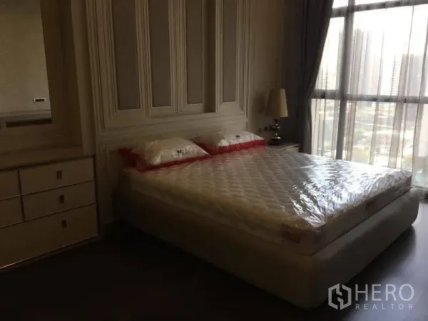 公寓 出租在Watthana, Bangkok - 卧室带装饰墙板，双人床，落地窗可观城市景。