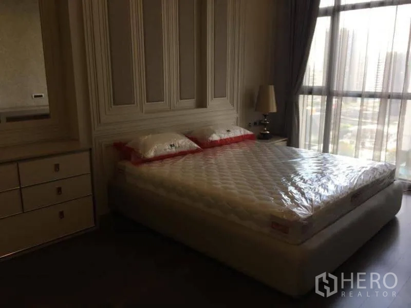 公寓 出租在Watthana, Bangkok - 卧室带装饰墙板，双人床，落地窗可观城市景。