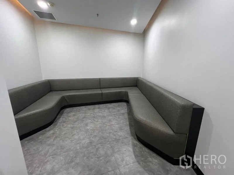办公空间 出租在Huai Khwang, Bangkok - 安静休息角，L 形内置沙发与瓷砖地面。