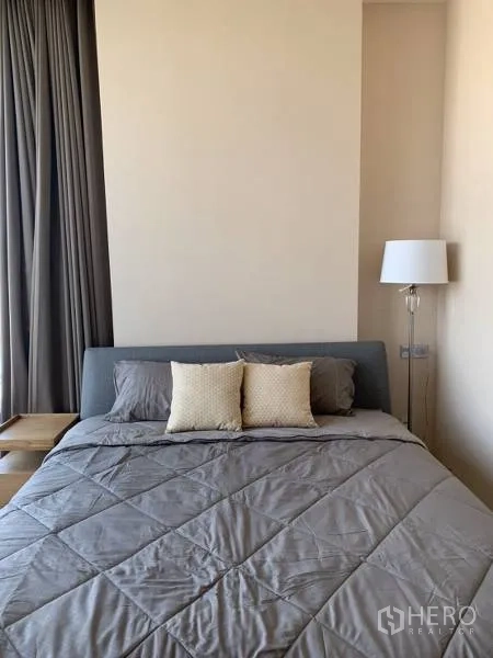 คอนโด ให้เช่าหรือขายในWatthana, Bangkok - ห้องนอนที่สองโทนสีอบอุ่น มีโคมไฟยืนและผ้าม่านสูงจรดเพดาน