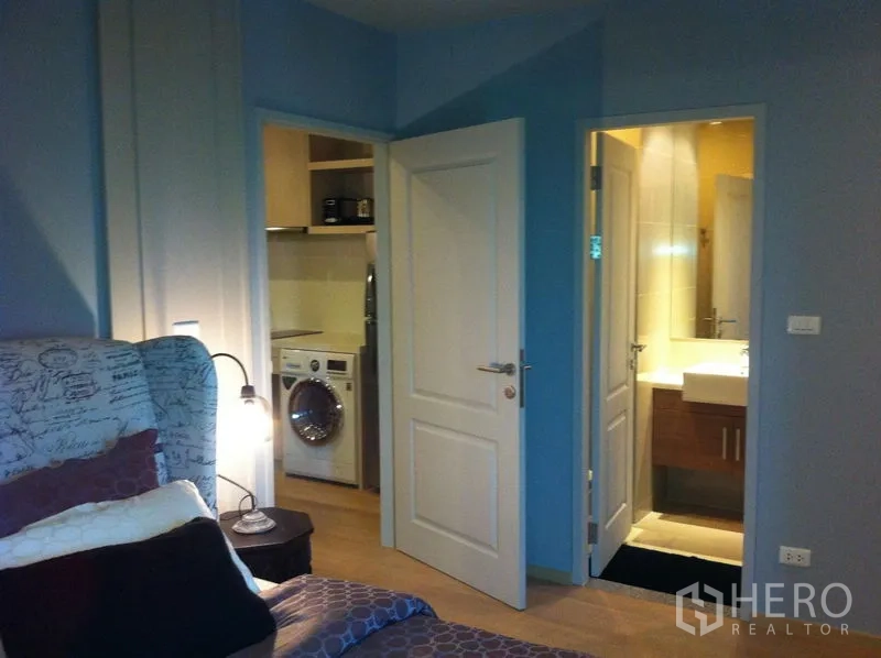 คอนโด ให้เช่าในBangkok - มุมห้องนอน เปิดประตูสู่ห้องน้ำและมุมซักล้างพร้อมเครื่องซักผ้า