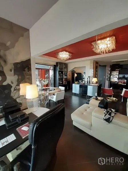 公寓 出租在Bang Na, Bangkok - 开放式起居与工作区，水晶吊灯、红色天花与皮沙发