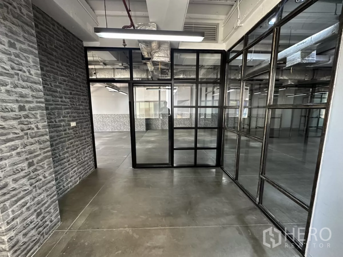 办公空间 出租 - 走道设有砖纹墙与黑框玻璃隔断。