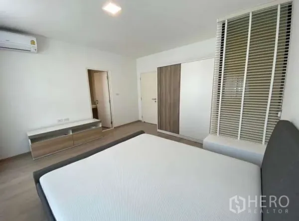 Townhouse for rent in Bang Phli, Samut Prakan - Master bedroom angle showing air conditioner, TV console and door to ensuite bathroom.