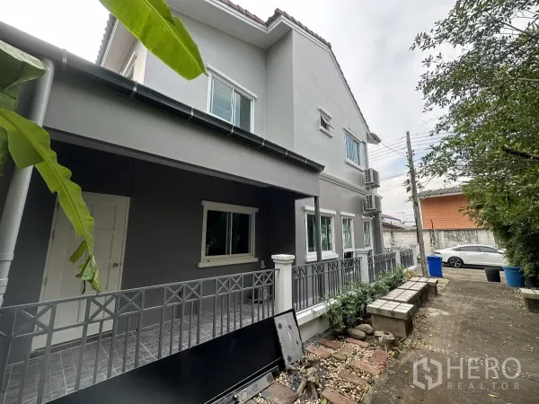 ทาวน์เฮาส์ ขายในLam Luk Ka, Pathum Thani - ทางเดินข้างบ้านพร้อมม้านั่งสวนและต้นไม้