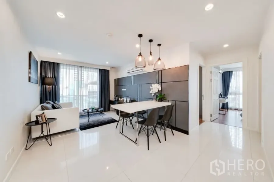 Condominium for sale in Bang Rak, Bangkok - Spacious 70 sqm layout showing living and dining zones with glossy tile floors and a corridor to the bedrooms.