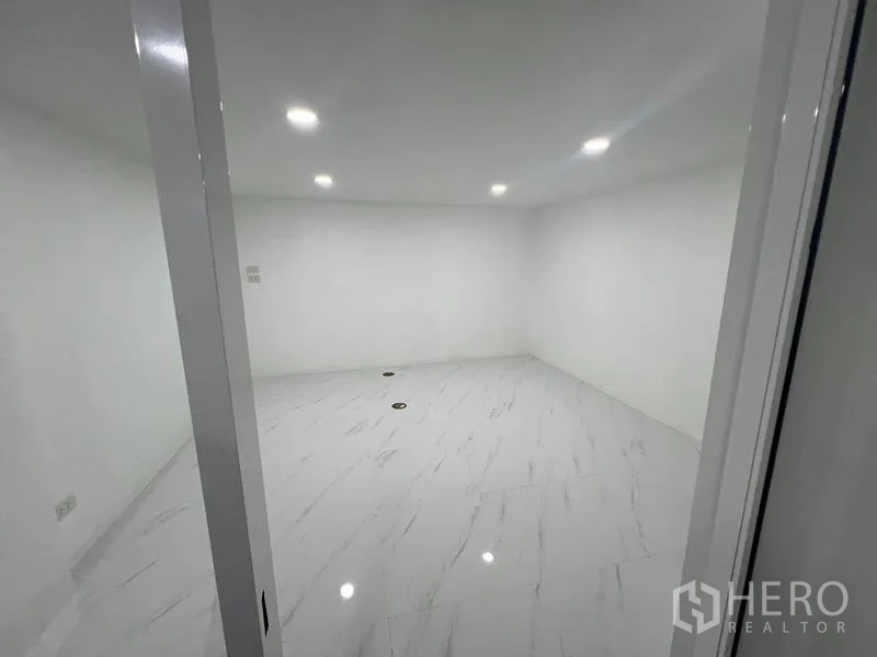 Office Space for rent or sale in Wang Thonglang, Bangkok - Bright enclosed office room with glossy white tiles and ceiling lights.