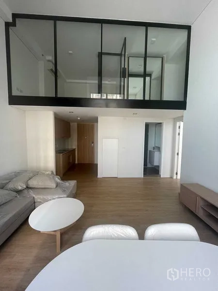 คอนโด ให้เช่าในKhlong Toei, Bangkok - พื้นที่นั่งเล่นและทานอาหารแบบโอเพน พร้อมโซฟา โต๊ะ และชั้นลอยกระจกด้านบน