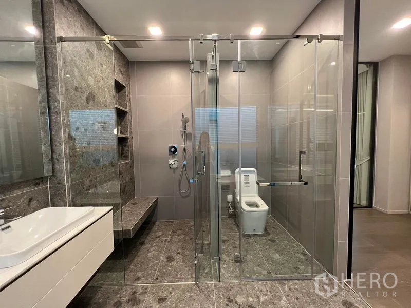 Detached House for sale in Saphan Sung, Bangkok - Contemporary bathroom with glass-enclosed shower and separate toilet area.