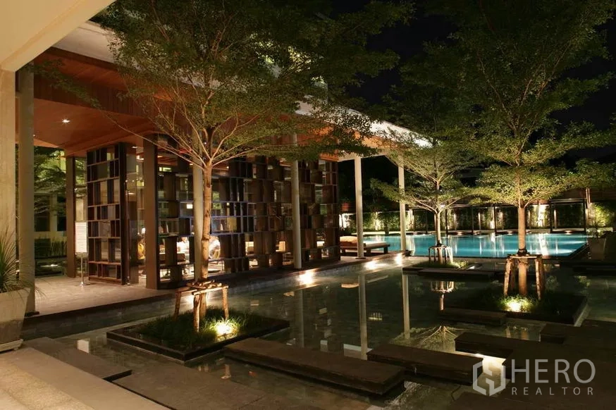 คอนโด ขายในKhlong Toei, Bangkok - สระว่ายน้ำสไตล์รีสอร์ทยามค่ำ พร้อมสวนน้ำ ต้นไม้ และศาลาพักผ่อนกลางแจ้ง