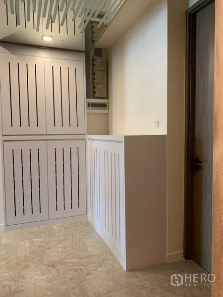 Condominium for sale in Khlong Toei, Bangkok - Utility area with slatted storage cabinets and a service door.