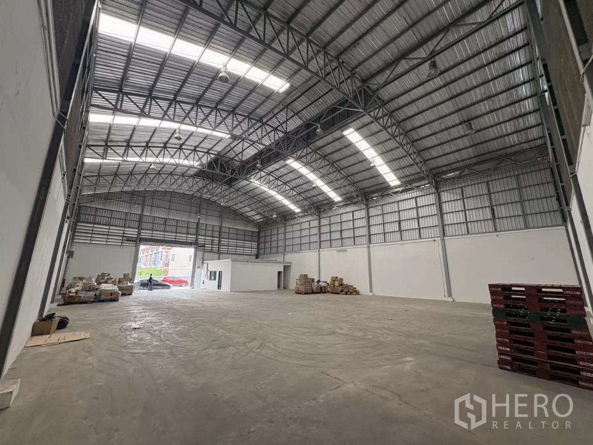 Warehouse for rent in Bang Phli, Samut Prakan - Clear-span storage hall showing large roller door and internal office block.
