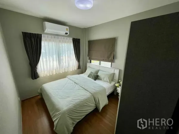 Townhouse for sale in Sai Mai, Bangkok - Bright bedroom with double bed, window drapes, and a wall-mounted air conditioner.