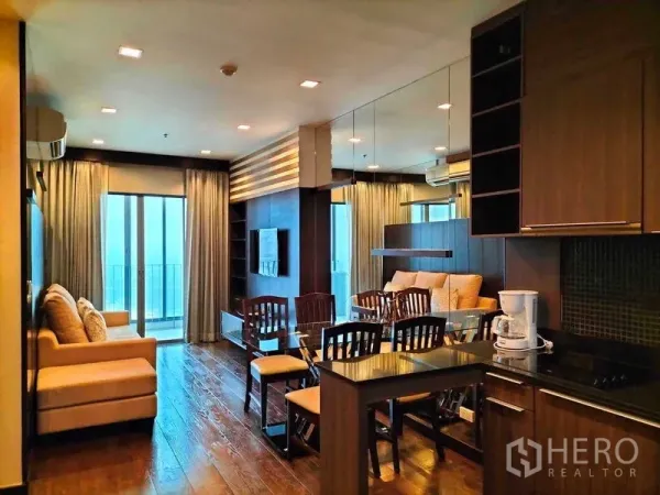 公寓 出租在Ratchathewi, Bangkok - 开放式客厅视角，连接厨房、镜面墙与餐桌并通阳台。