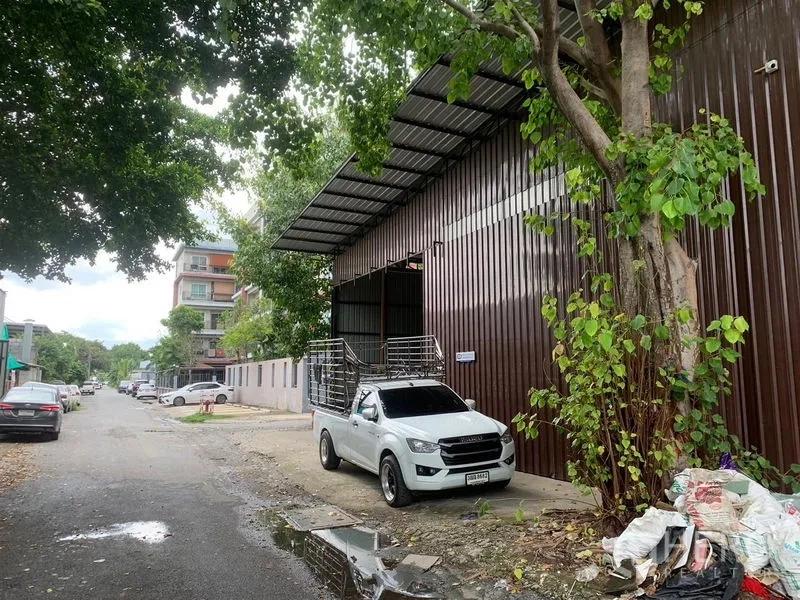 Warehouse for rent in Bang Kapi, Bangkok - Street view of a brown metal warehouse with covered loading bay and roadside parking in Bang Kapi.