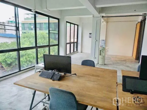 带办公室的家 出租或出售在Din Daeng, Bangkok - 转角办公室，三面采光，木质书桌，可见城市与树木景观。