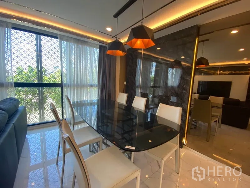 ทาวน์เฮาส์ ขายในYan Nawa, Bangkok - มุมรับประทานอาหารโต๊ะกระจกสีดำ โคมไฟแขวนสไตล์โมเดิร์น และวิวหน้าต่างข้างผนังกระจกเงา